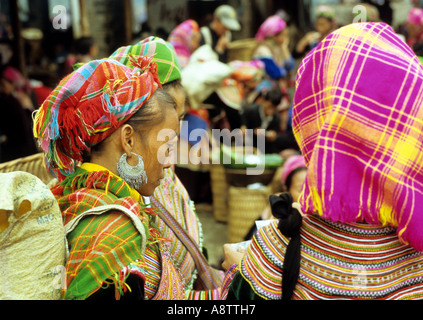 Due fiori donne Hmong in colorate abbigliamento tradizionale presso il mercato della domenica, Bac Ha, NW Viet Nam Foto Stock