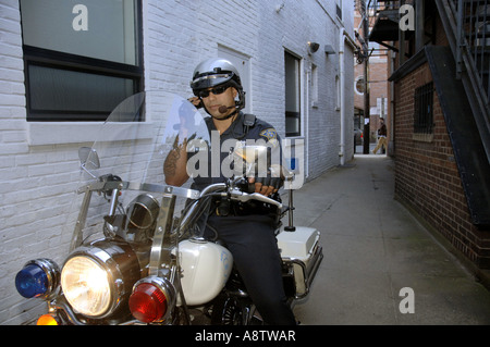 New Haven, CT. Motociclo ispanica poliziotto sulla sua Harley Davidson Moto i colloqui per la radio in uno stretto vicolo. Foto Stock