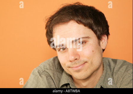 Studio shot del giovane uomo adulto con un sorriso casual Foto Stock