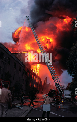 I vigili del fuoco e il fotografo che frequentano la masterizzazione di edificio industriale in Chippendale. Sydney. Australia.1980s. Foto Stock