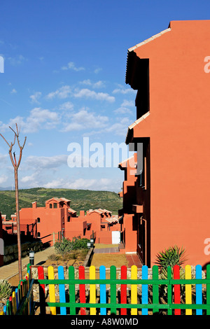 Salmone, di colore rosso o arancione appartamenti sull urbanizzazione spagnola sulla Costa del Sol in Spagna con sunny cielo blu e vernice colorata Foto Stock