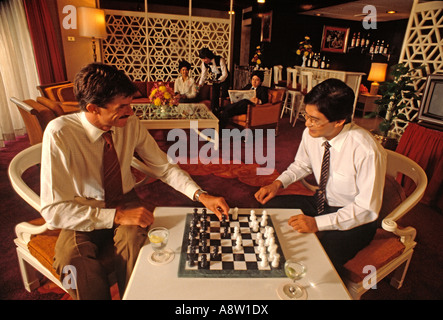Due uomini seduti al chiuso la riproduzione di un gioco di scacchi nella lounge dell'hotel. Foto Stock