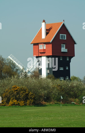 Thorpeness Stuart Ogilvie s la casa tra le nuvole costruito per nascondere una torre di acqua che si vede attraverso il campo da golf con il mulino a vento Foto Stock