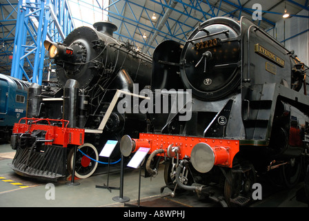 La 9F nella classe "stella della sera", l'ultima locomotiva a vapore costruita per British Rail al fianco di un trasporto merci cinesi locomoive. Foto Stock