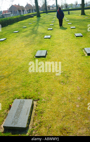 Il cimitero militare tedesco a Langemark, Belgio con una figura camminare tra le lapidi. Foto Stock