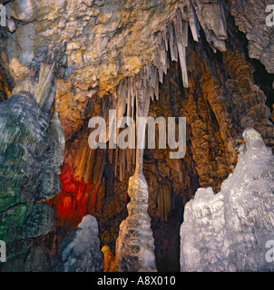 Scenograficamente illuminato in maniera colorata di stalattiti e stalagmiti in Auditorium area di St Michaels Grotta Gibilterra Foto Stock