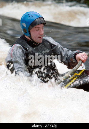 Un canoeist battaglie il torrente acque del fiume Dart in Devon England Foto Stock