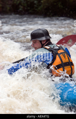 Un canoeist battaglie il torrente acque del fiume Dart in Devon England Foto Stock