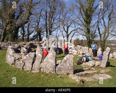 Din Capanna Lligwy cerchio con gli escursionisti in appoggio all'interno rimane del IV secolo ha difeso l'insediamento. Moelfre Anglesey North Wales Foto Stock