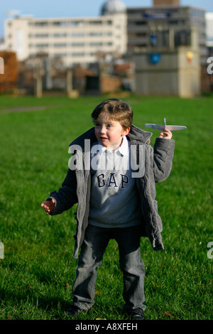 Cinque anni di vecchio ragazzo nel parco battenti un giocattolo glider Foto Stock