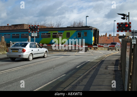 Treni pendolari passando al di sopra di un passaggio a livello a Filey North Yorkshire, Inghilterra Foto Stock