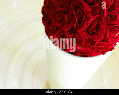 Sfera di rose rosse in un pallido vaso colorati sul tavolo Foto Stock