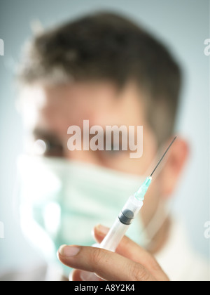 Un lavoratore di salute circa per somministrare il farmaco al paziente tramite iniezione Foto Stock