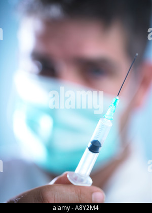 Un lavoratore di salute circa per somministrare il farmaco al paziente tramite iniezione Foto Stock