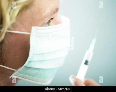 Un lavoratore di salute circa per somministrare il farmaco al paziente tramite iniezione Foto Stock