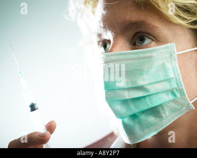 Un lavoratore di salute circa per somministrare il farmaco al paziente tramite iniezione Foto Stock