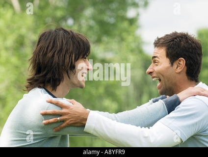 Due giovani amici maschi tenendo reciprocamente le spalle e ridere Foto Stock