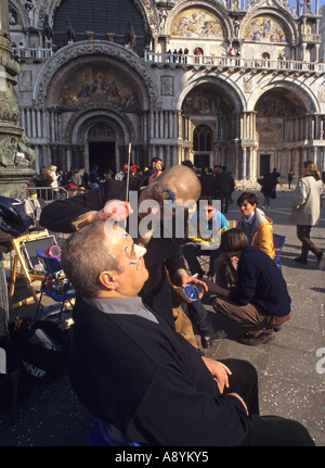 L'artista di strada dipinto il volto di un turista durante il Carnevale in Piazza San Marco Venezia Italia Foto Stock