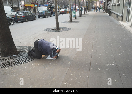 Uomo di elemosinare sulla strada di Parigi Foto Stock