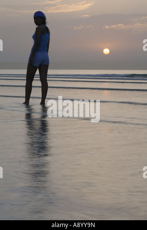 Femmina Lone camminando lungo la spiaggia. Foto Stock