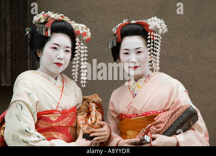 Due belle giapponesi turisti pongono come Geisha a Kyoto il quartiere di Gion. Foto Stock