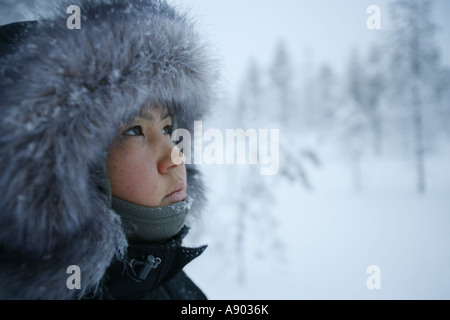 Turista femminile guardando la neve coperto da alberi di pino in Lapponia la natura artica. Foto Stock