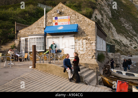 Scivolo per imbarcazione di lancio e di turista giovane al di fuori di Lulworth Cove beach cafe Dorset Regno Unito Foto Stock