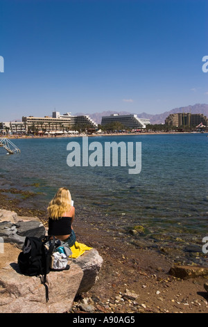 Una donna sulla riva si affaccia Eilat Foto Stock