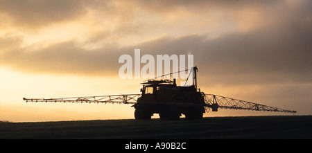 Silhouette sullo sfondo di un cielo di agricoltura irroratrice di raccolto montato su camion che lavorano su collina campo agricolo Essex Inghilterra UK Foto Stock