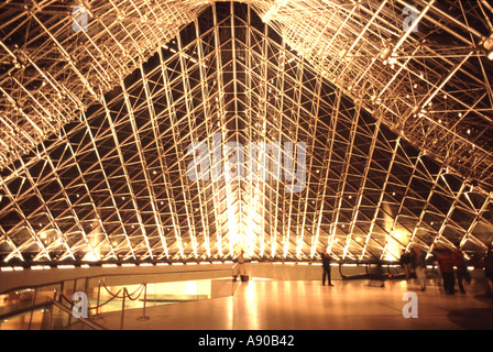 Parigi Francia la moderna piramide del Louvre la costruzione di piano terra con ingresso concourse illuminazione interna di notte disegnata da Ieoh Ming Pei Foto Stock