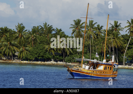 Imbarcazione a vela in legno ormeggiata in mare nei pressi di una coperta di Palm Beach, Maldive. Foto Stock