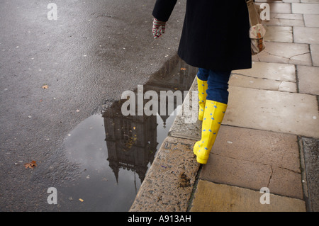 Westminister Abby in riflessione con stivali di colore giallo sul marciapiede. Foto Stock