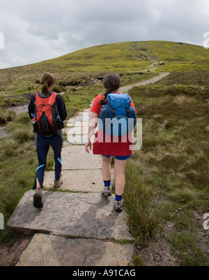 Le donne gli escursionisti su pietre poste sulla sezione paludosa della distanza lungo il sentiero che conduce a Offa's Dyke le montagne nere Wales UK Foto Stock