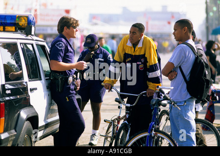 La polizia e gli adolescenti sulla bicicletta in Venice, California. Foto Stock