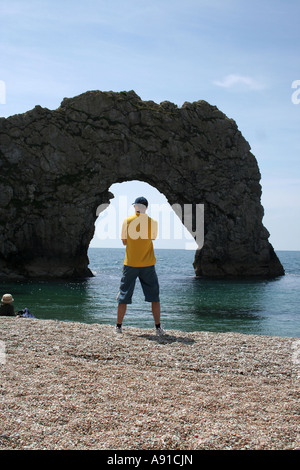 Un uomo si presentò nell'arco di Durdle Dor nell Inghilterra del Sud Foto Stock