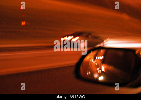 Veloce Auto su un alto titolo con vista attraverso lo specchietto retrovisore Foto Stock