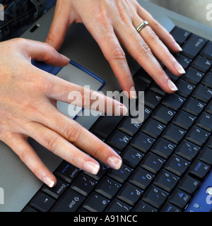 Womans mani digitando su una tastiera portatile Foto Stock