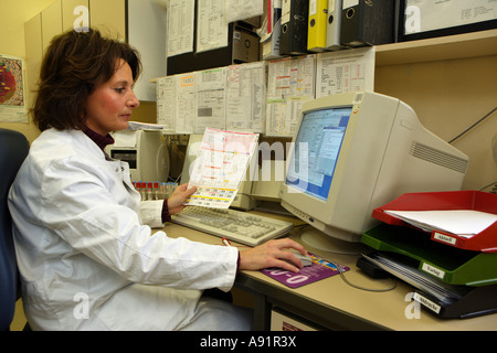 Il Medico assistente tecnico controlla gli esami del sangue Foto Stock