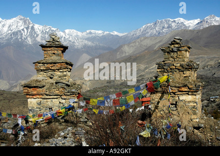 Due vecchie choerten con colorati bandiere di preghiera e le montagne ricoperte di neve Muktinath Mustang Regione Annapurna Nepal Foto Stock