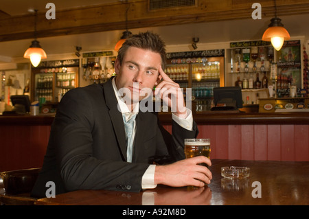 L'uomo avente una pinta in un pub Foto Stock