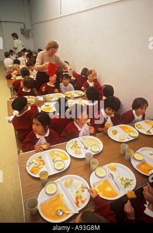 Bambini della scuola multiculturale infantile che hanno un pranzo sano nella mensa scolastica Foto Stock