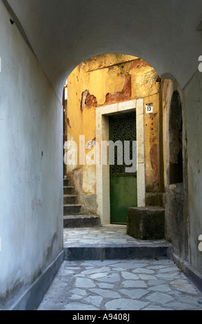 Archway nella città italiana di castlemola cercando su di una rustica casa italiana con pareti gialle e porta verde Foto Stock