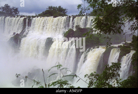 In alto di Iguazu falls visto attraverso gli alberi dal Brasile Parana laterale Foto Stock