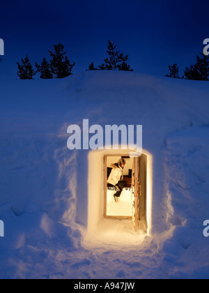 Donna dentro la neve Igloo in hotel e villaggio igloo, Kakslauttanen, situato nel Saariselk cadde area della Lapponia, Finlandia Foto Stock
