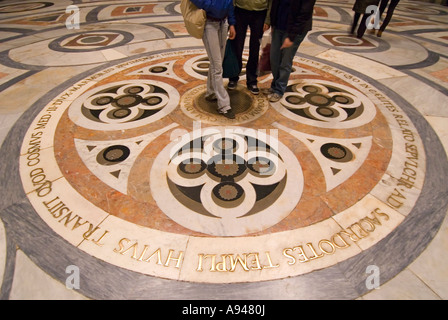 Chiudere orizzontale del marmo antico pavimento intarsiato all'interno del Duomo con i turisti in piedi guardando l'iscrizione. Foto Stock