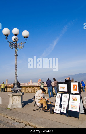 Vista verticale di un artista e i suoi dipinti con turisti che si godono la vista dal Piazzale Michelangelo in una giornata di sole. Foto Stock