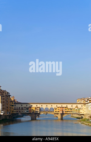 Verticale ampia angolazione del Ponte Vecchio " Ponte Vecchio e sul fiume Arno contro un luminoso cielo blu Foto Stock