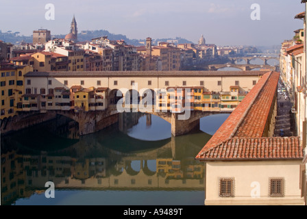 Antenna orizzontale vista del Ponte Vecchio e il corridoio Vasari e il fiume Arno in una luminosa giornata di sole. Foto Stock