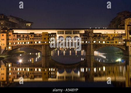 Orizzontale fino in prossimità del Ponte Vecchio [old bridge] illuminata di notte si riflette nel fiume Arno. Foto Stock