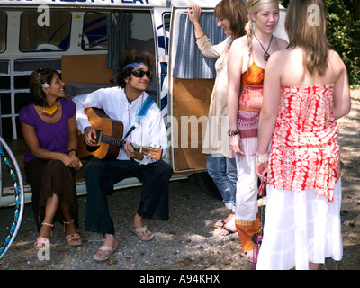 I giovani in una piccola comunità Hippy con un Camper Van godendo di uno stile di vita rilassante evitando le pressioni della società quotidiana e la vita Foto Stock